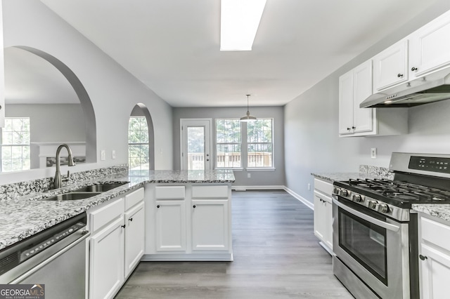 5452 Sweetsprings Dr SW, Powder Springs, GA 30127 - kitchen with white cabinets, appliances with stainless steel finishes, a sink, light wood-type flooring, and under cabinet range hood