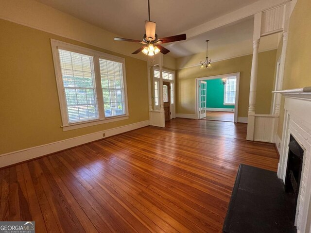 589 Meigs St, Athens, GA 30601 - unfurnished living room featuring ceiling fan with notable chandelier, baseboards, a brick fireplace, and wood finished floors