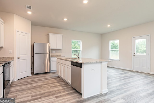 kitchen with a sink, stainless steel appliances, white cabinetry, light wood-type flooring, and visible vents