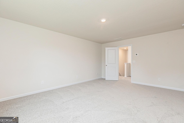 unfurnished room featuring baseboards, recessed lighting, and light carpet