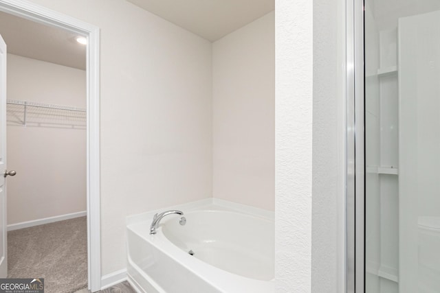 102 Avondale Blvd, Conyers, GA 30013 - bathroom with an enclosed shower, baseboards, a spacious closet, and a bath