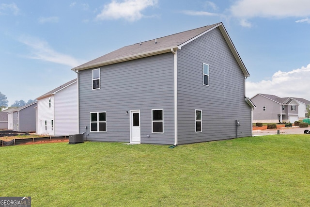 rear view of property featuring a yard and cooling unit