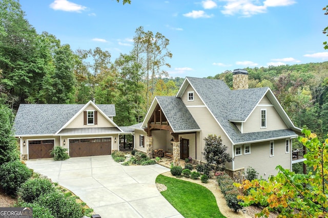 craftsman inspired home featuring driveway, a chimney, a garage, a shingled roof, and stone siding