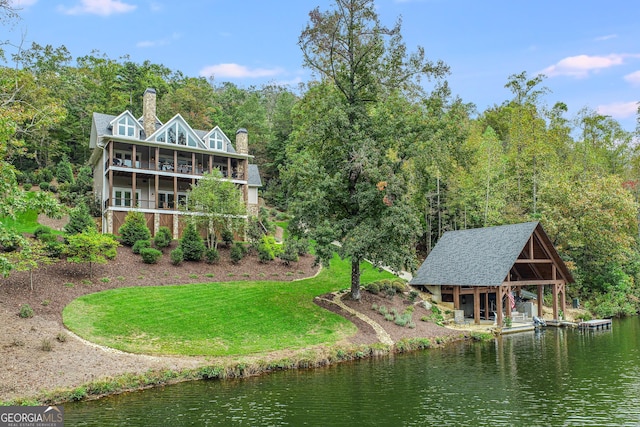 view of home's community with a lawn, a view of trees, and a water view
