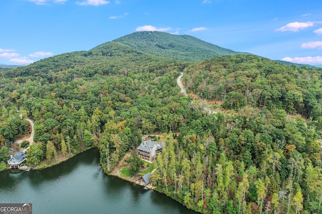 birds eye view of property with a view of trees and a water and mountain view