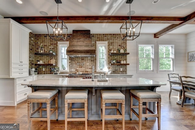 676 N Shore Dr, Cleveland, GA 30528 - kitchen with open shelves, custom exhaust hood, plenty of natural light, a chandelier, and beamed ceiling