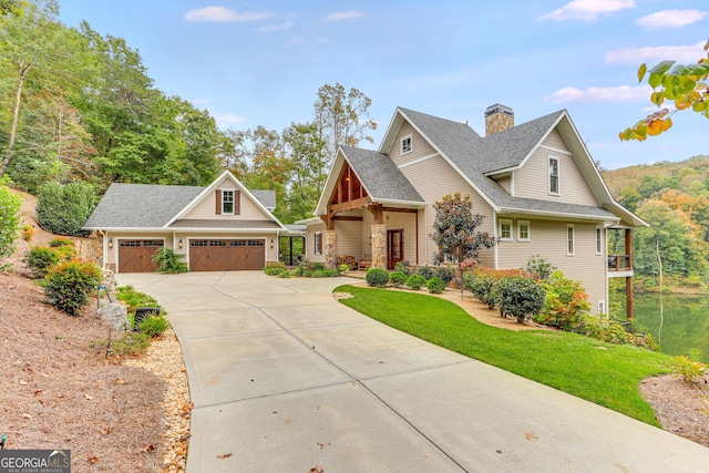 craftsman house featuring a chimney, roof with shingles, an outdoor structure, a front lawn, and concrete driveway