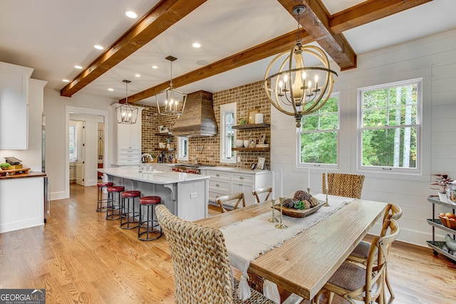 dining space featuring an inviting chandelier, beamed ceiling, recessed lighting, and light wood-style flooring