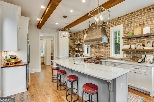 kitchen with open shelves, light wood-style flooring, beam ceiling, and white cabinetry