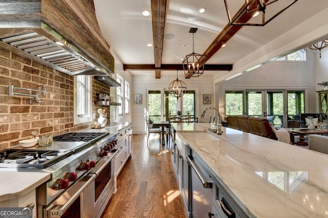 676 N Shore Dr, Cleveland, GA 30528 - kitchen featuring stainless steel appliances, wall chimney exhaust hood, a sink, wood finished floors, and beam ceiling