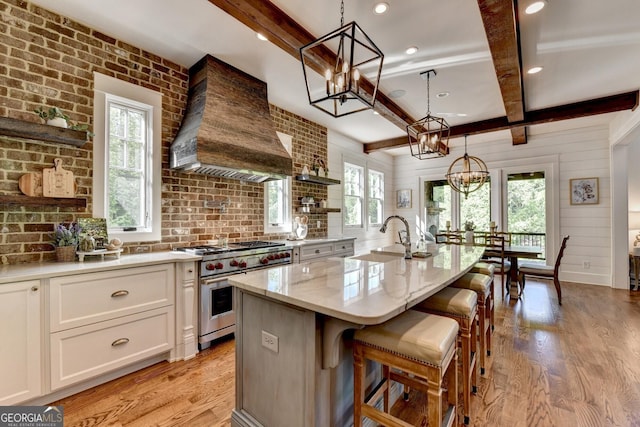 676 N Shore Dr, Cleveland, GA 30528 - kitchen featuring double oven range, custom range hood, a sink, a chandelier, and light wood-type flooring