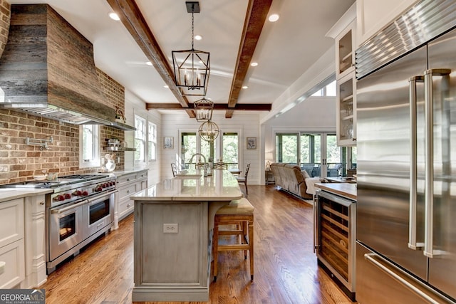 676 N Shore Dr, Cleveland, GA 30528 - kitchen with high end appliances, wine cooler, beamed ceiling, open floor plan, and light wood finished floors