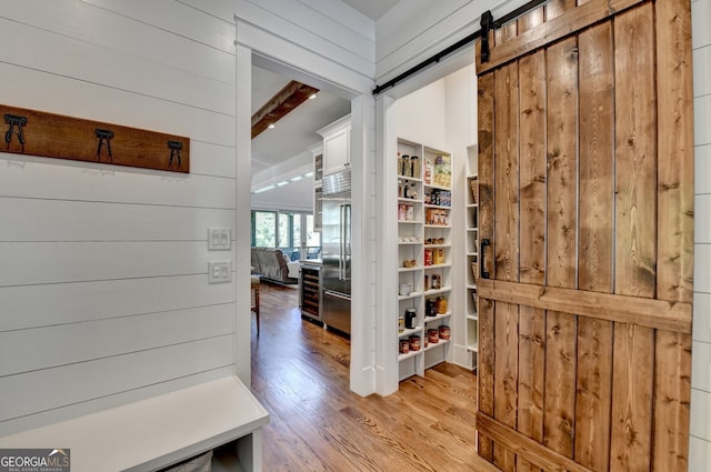 676 N Shore Dr, Cleveland, GA 30528 - mudroom with light wood finished floors, wooden walls, a barn door, and beam ceiling
