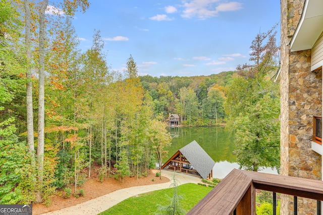 property view of water with a wooded view and a boat dock