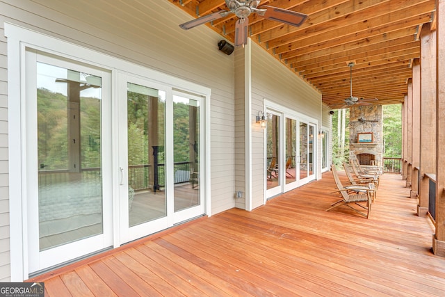 wooden terrace with a ceiling fan and french doors