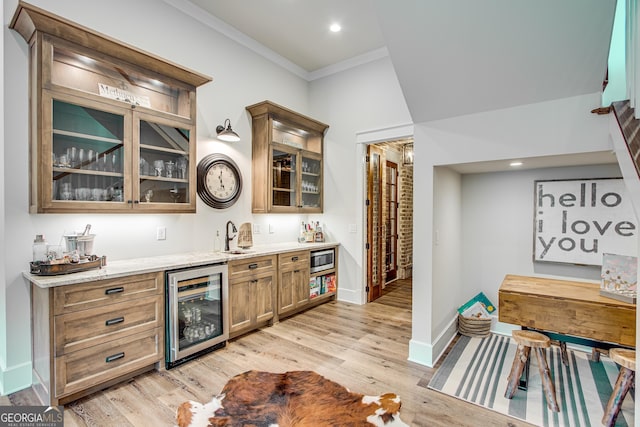 bar featuring ornamental molding, wine cooler, indoor wet bar, baseboards, and stainless steel microwave