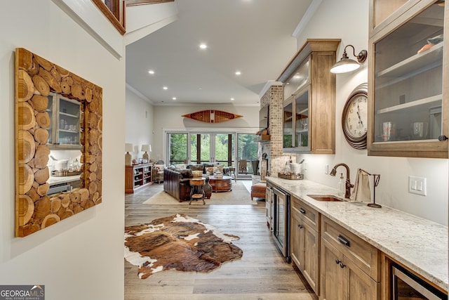 bar featuring indoor wet bar, ornamental molding, light wood-style flooring, and wine cooler