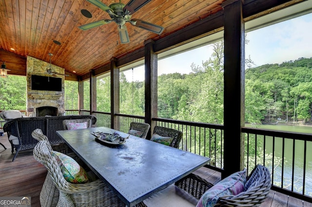 676 N Shore Dr, Cleveland, GA 30528 - sunroom with an outdoor stone fireplace, ceiling fan, outdoor dining space, vaulted ceiling, and a view of trees
