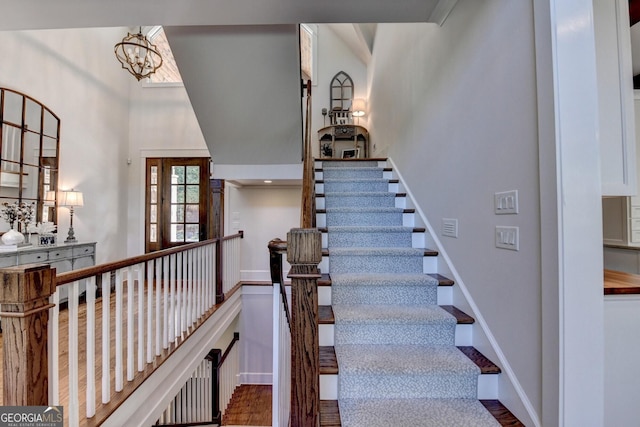 676 N Shore Dr, Cleveland, GA 30528 - staircase with a high ceiling, a chandelier, wood finished floors, and baseboards