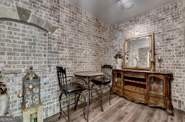 676 N Shore Dr, Cleveland, GA 30528 - dining area with wood finished floors and brick wall