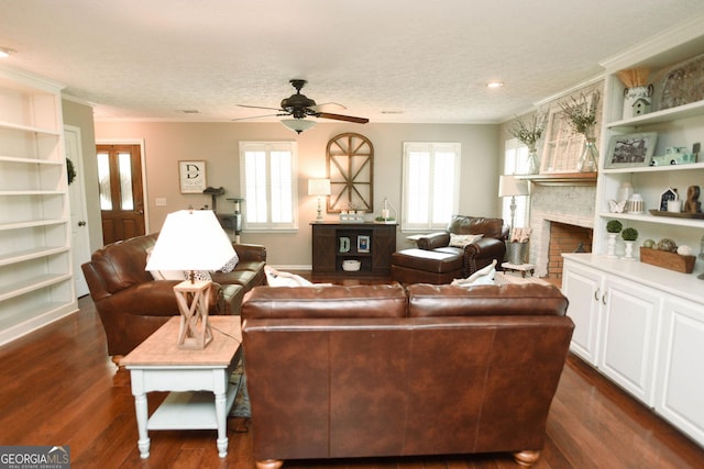 1737 Green Acres Dr, Vidalia, GA 30474 - living area with crown molding, ceiling fan, a fireplace, a textured ceiling, and dark wood-type flooring