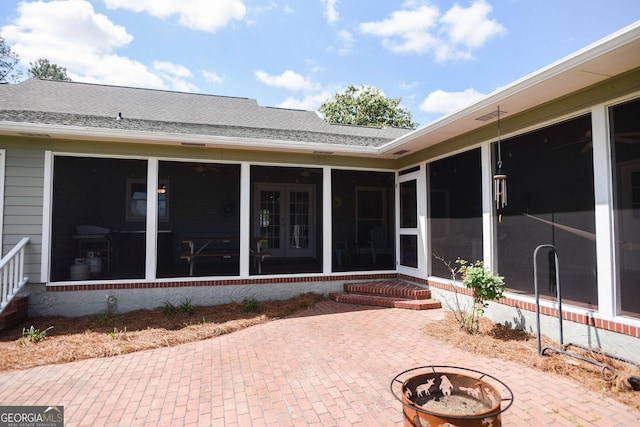 1737 Green Acres Dr, Vidalia, GA 30474 - rear view of property featuring french doors, roof with shingles, a patio area, a sunroom, and a fire pit
