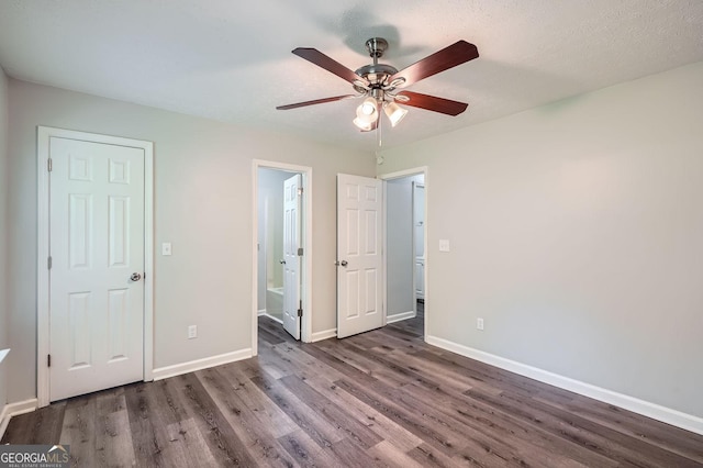 7112 Greenway Cv SW, Covington, GA 30014 - unfurnished bedroom featuring a ceiling fan, baseboards, wood finished floors, and ensuite bath