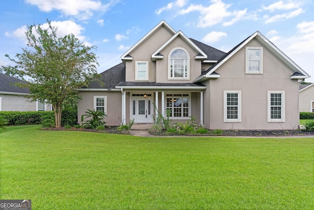 102 Herons Nest Cir, Kingsland, GA 31548 - view of front facade featuring covered porch, a shingled roof, a front yard, and stucco siding