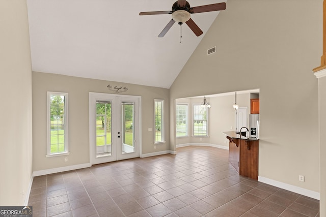 102 Herons Nest Cir, Kingsland, GA 31548 - unfurnished living room with visible vents, baseboards, ceiling fan, high vaulted ceiling, and dark tile patterned floors