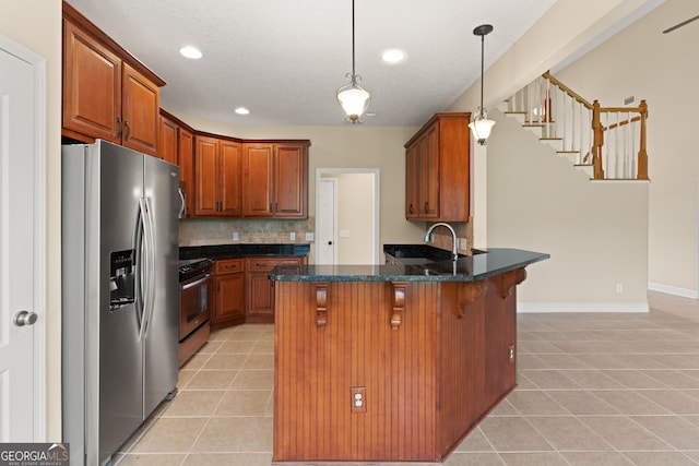 102 Herons Nest Cir, Kingsland, GA 31548 - kitchen with stainless steel appliances, a kitchen breakfast bar, light tile patterned floors, and a peninsula