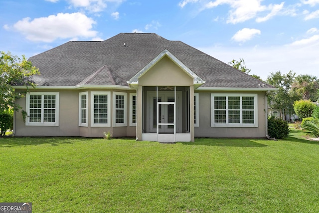 102 Herons Nest Cir, Kingsland, GA 31548 - back of property featuring roof with shingles, a yard, stucco siding, and a sunroom