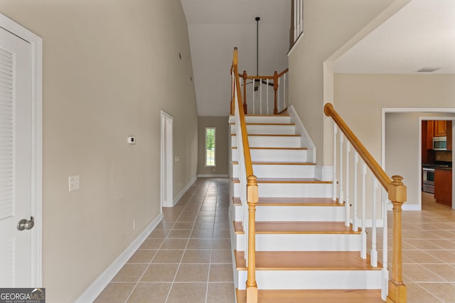 102 Herons Nest Cir, Kingsland, GA 31548 - stairway featuring tile patterned floors, visible vents, baseboards, and a towering ceiling