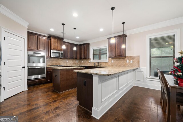 1314 Bentley Estates Dr, Dacula, GA 30019 - kitchen with appliances with stainless steel finishes, ornamental molding, dark brown cabinets, dark wood-style flooring, and a center island