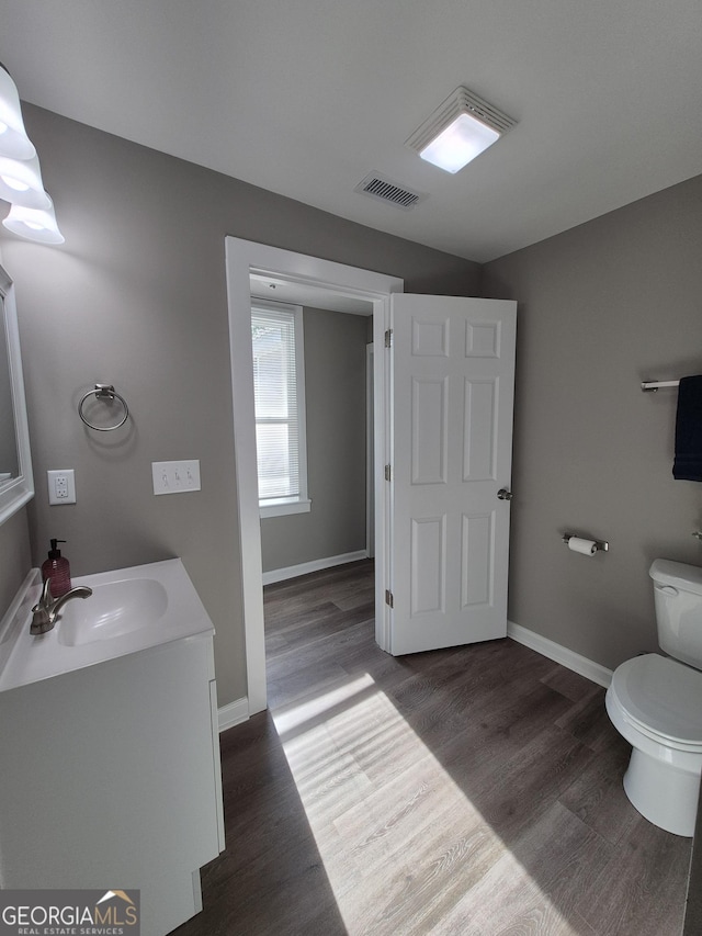 127 S Church St, Bogart, GA 30622 - bathroom with baseboards, toilet, visible vents, vanity, and wood finished floors