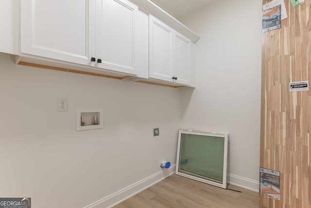 4731 H D Atha Rd, Covington, GA 30014 - washroom with hookup for an electric dryer, washer hookup, light wood-style floors, and cabinet space