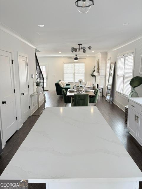 kitchen with plenty of natural light, dark wood-type flooring, ornamental molding, baseboards, and recessed lighting