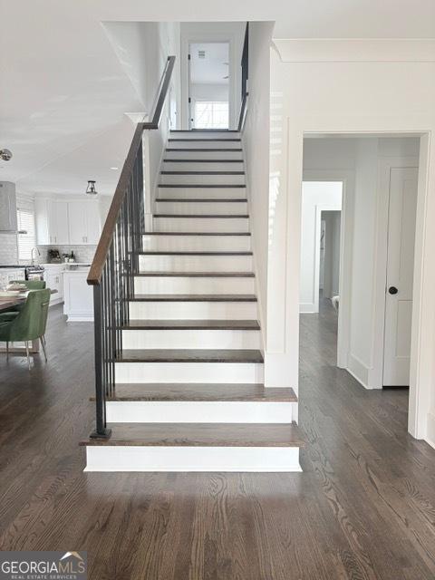 staircase with wood finished floors and baseboards