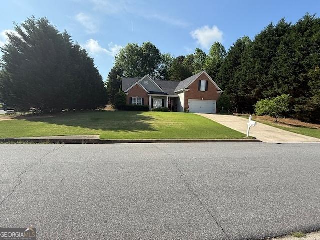 traditional-style home with a garage, concrete driveway, and a front yard