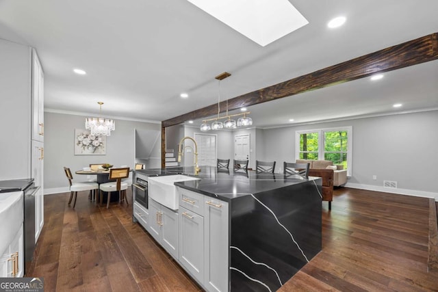 kitchen featuring a sink, pendant lighting, recessed lighting, and dark wood-type flooring