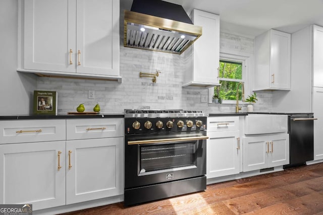 kitchen with wall chimney range hood, white cabinets, dark wood-style flooring, high end stainless steel range, and decorative backsplash
