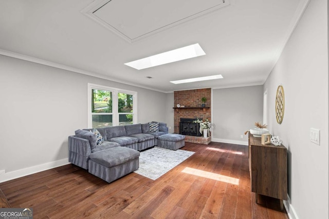 living room with crown molding, baseboards, wood finished floors, and a fireplace