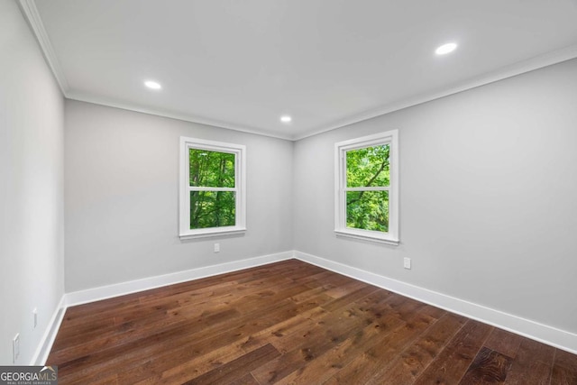 unfurnished room featuring plenty of natural light, ornamental molding, dark wood finished floors, and baseboards