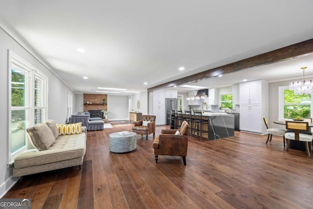 living room with recessed lighting, an inviting chandelier, dark wood-style floors, and a fireplace