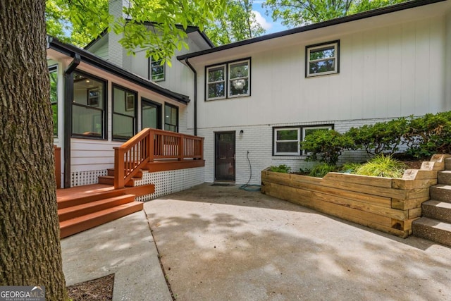 back of property with a sunroom, a patio area, and brick siding