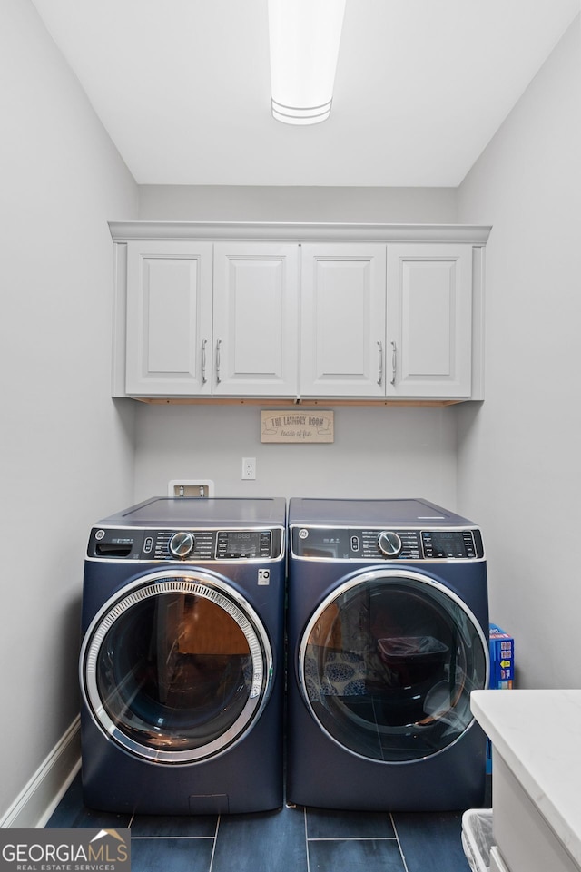 laundry area with cabinet space, separate washer and dryer, baseboards, and tile patterned flooring