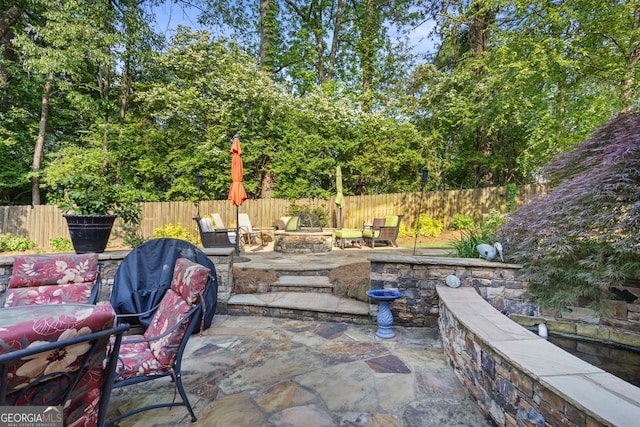 view of patio / terrace featuring fence and an outdoor fire pit
