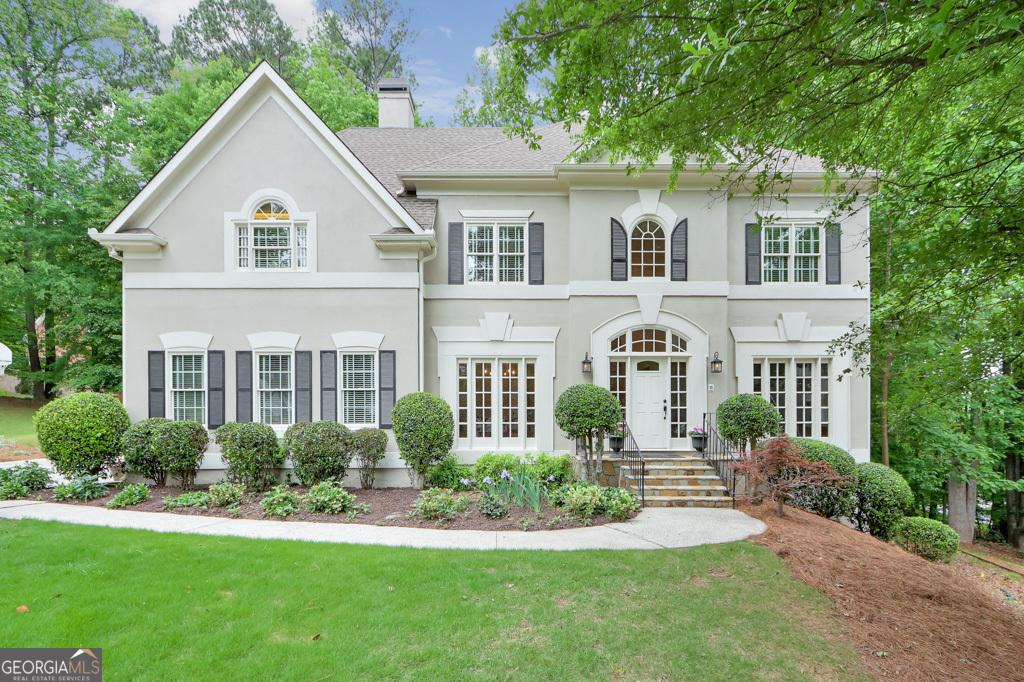 9900 Hunt Club Way, Johns Creek, GA 30022 - view of front facade with a front lawn, stucco siding, french doors, and a chimney