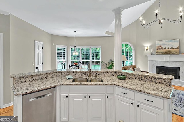 kitchen featuring light stone countertops, a sink, light wood finished floors, and dishwasher