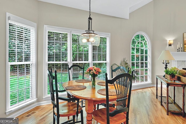 dining room featuring baseboards, light wood-style flooring, a notable chandelier, and visible vents