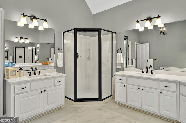 bathroom with a sink, a shower stall, marble finish floor, and lofted ceiling